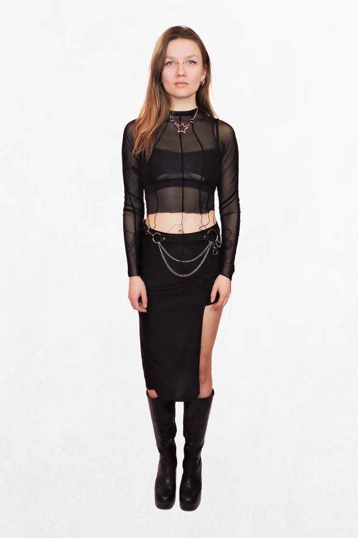 A lightweight, see-through black mesh top with long sleeves. The structured panel design creates subtle contrast, making it a versatile piece for styling with streetwear, lingerie, or alternative fashion.