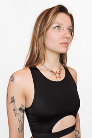 Model wearing a silver chain choker with a bold star in the center. The chain wraps around the neck, with the star acting as the striking focal point of the piece.