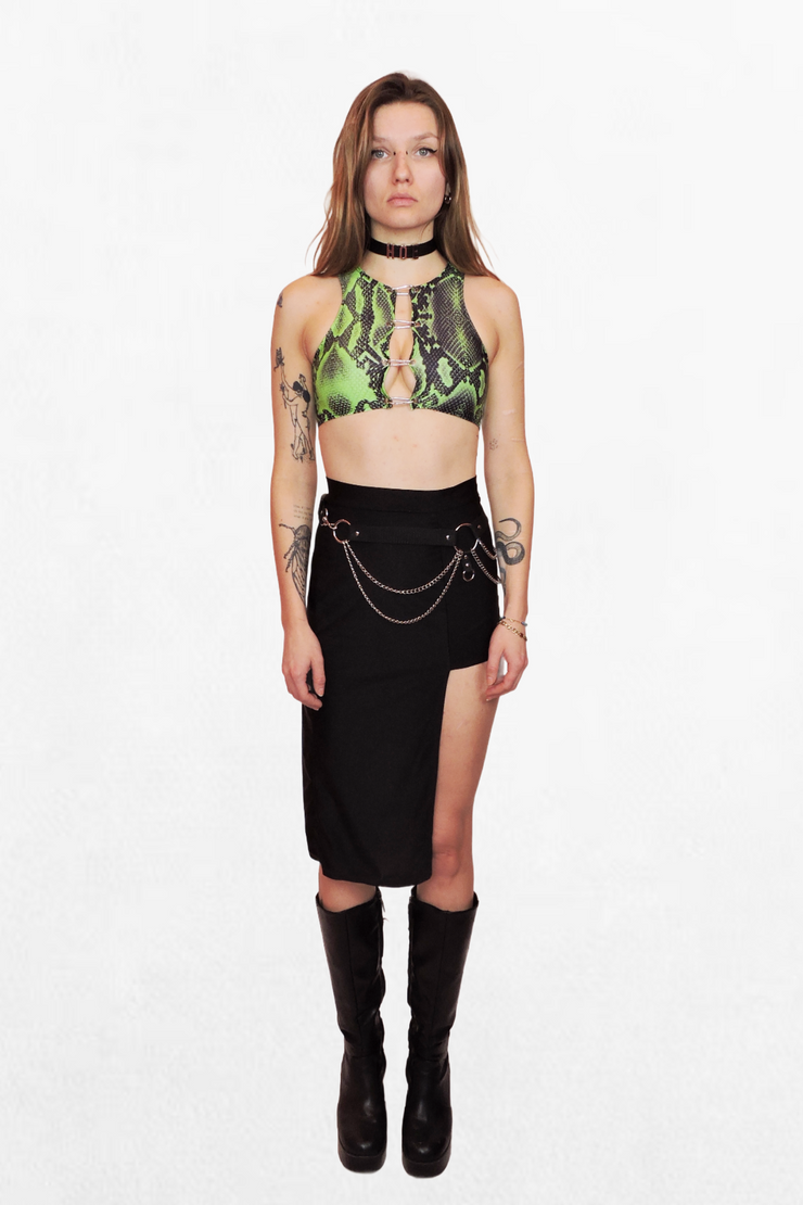 Model wearing a fitted green and black snake print crop top, secured with silver carabiner closures. The bold pattern and sleek fit make it a statement piece for any edgy look.